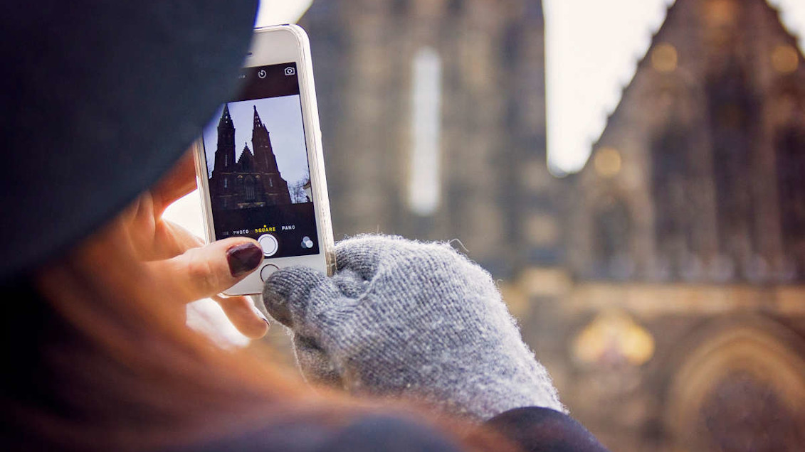 chica sacando una foto de una iglesia con el móvil
